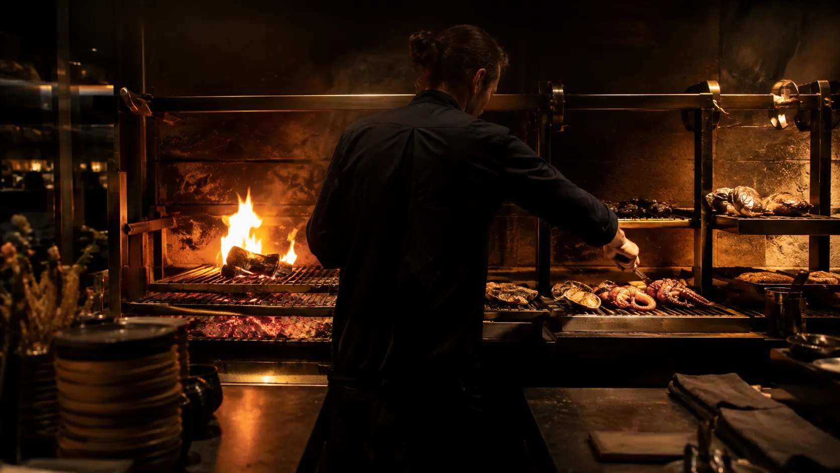 Lo chef lavora alla brace nel buio caldo della cucina